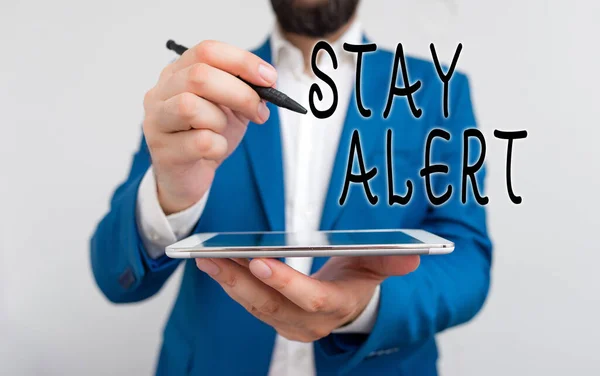 Handwriting text Stay Alert. Concept meaning Paying full attention to things around Quick to see or understand Businessman pointing with pen in empty copy space.