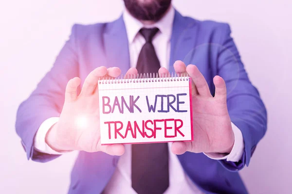 Word writing text Bank Wire Transfer. Business concept for Electronic transfer of money through bank to bank Man holds empty paper with copy space in front of him Copy Space.