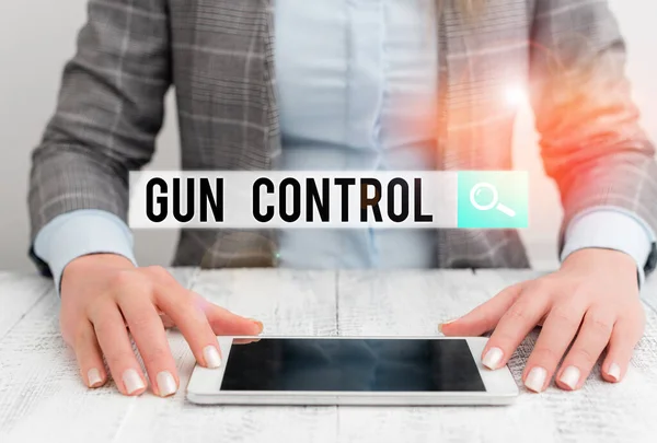 Manuscrito texto Gun Control. Conceito que significa medida legal destinada a restringir a posse de armas Mulher de negócios sentada com telefone celular na mesa . — Fotografia de Stock