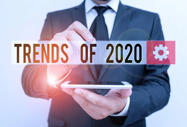 Text sign showing Trends Of 2020. Conceptual photo things that is famous for short period of time in current year Male human wear formal work suit hold smart hi tech smartphone use one hand. — 图库照片