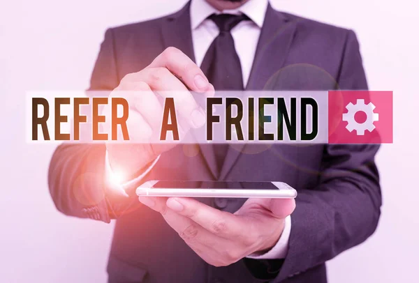 Text sign showing Refer A Friend. Conceptual photo Recommendation Appoint someone qualified for the task Male human wear formal work suit hold smart hi tech smartphone use one hand. — Stock Photo, Image