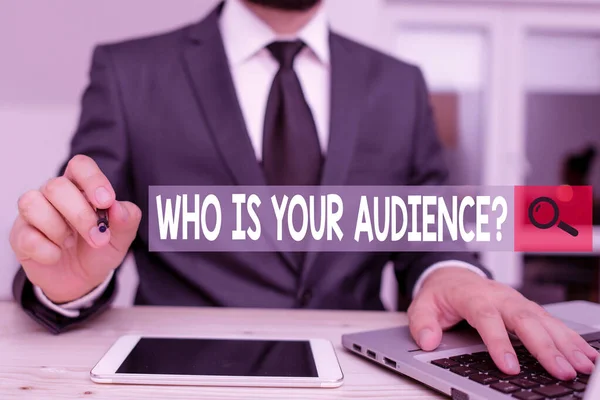 Text sign showing Who Is Your Audience Question. Conceptual photo who is watching or listening to it Male human wear formal clothes present presentation use hi tech smartphone.