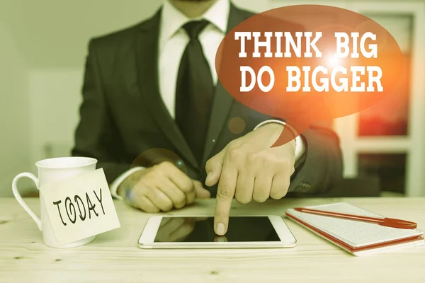 Escritura de texto a mano Think Big Do Bigger. Concepto que significa elevar el listón y apuntar mucho más alto que el habitual desgaste humano masculino ropa formal presente presentación uso de teléfono inteligente de alta tecnología . — Foto de Stock