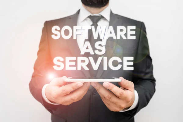 Text sign showing Software As Service. Conceptual photo On Deanalysisd licensed on Subscription and centrally hosted Male human wear formal work suit hold smart hi tech smartphone use hands.