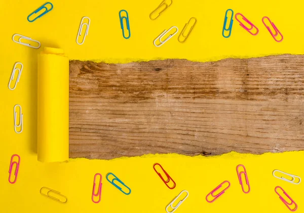 Gescheurd karton met paperclip geplaatst boven een houten klassieke tafel. Dik gescheurd papier en stilstaand op een getextureerd houten achtergrond. Artistieke manier om plat te leggen fotografie — Stockfoto