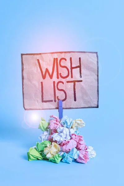 Word writing text Wish List. Business concept for List of desired but often realistically unobtainable items Reminder pile colored crumpled paper clothespin reminder blue background.