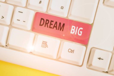 Dream Big 'i gösteren kavramsal el yazısı. Hayatınız için amaç arayan iş fotoğrafı metni ve işlemde beyaz arkaplan üzerinde not kağıdı ile yerine getiriliyor.