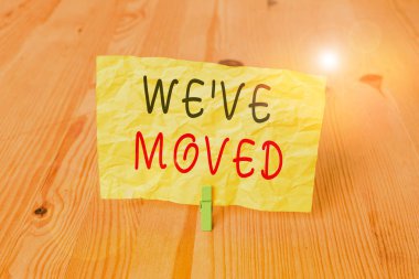 Taşındığımızı gösteren kavramsal el yazısı. İş fotoğrafı metni Bir konuttan başka bir yere gitmek için Tahta zemin zemin arkaplanı yeşil çamaşır mandalı oyuk ofisi.