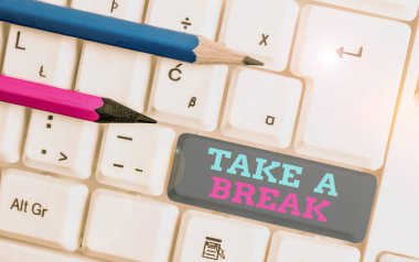 Conceptual hand writing showing Take A Break. Business photo showcasing Resting Stop doing something recreation time get out of work White pc keyboard with note paper above the white background.