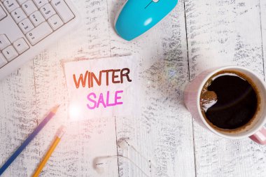 Kış Satışı el yazısı. Kavram, yıl sonunda sunulan indirimler anlamına geliyor. Bayram satışları düşük fiyatlar teknolojik cihazlar renkli hatırlatma kağıt ofis klavye fare tedarik.