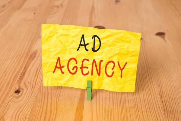 Conceptual hand writing showing Ad Agency. Business photo text business dedicated to creating planning and handling advertising Wooden floor background green clothespin groove slot office.