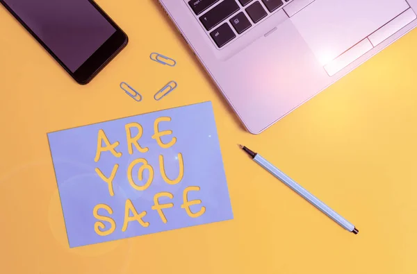 Conceptual hand writing showing Are You Safe. Business photo showcasing Free from danger Not anticipating any Harm Hurt physically Trendy open laptop smartphone marker paper sheet clips. — 图库照片