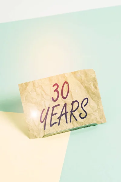 Woord schrijven tekst 30 Jaar. Business concept voor Herinneren of eren van speciale dag voor het bestaan van 30 jaar Papier gekanteld boven bufferdraad op zachte pastel multi kleuren achtergrond. — Stockfoto