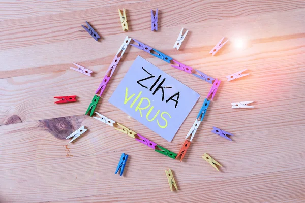 Word writing text Zika Virus. Business concept for caused by a virus transmitted primarily by Aedes mosquitoes Colored clothespin papers empty reminder wooden floor background office.