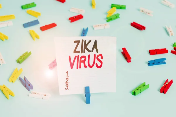 Word writing text Zika Virus. Business concept for caused by a virus transmitted primarily by Aedes mosquitoes Colored clothespin papers empty reminder blue floor background office pin.