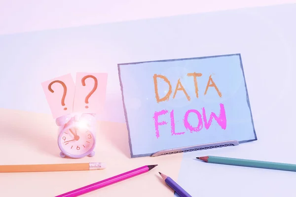 Writing note showing Data Flow. Business photo showcasing the movement of data through a system comprised of software Mini size alarm clock beside stationary on pastel backdrop. — ストック写真