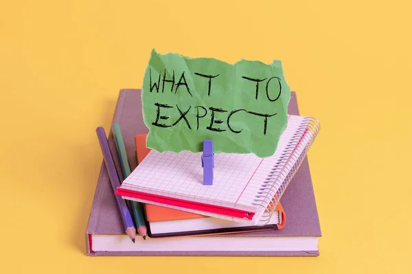 Text sign showing What To Expect. Conceptual photo Confusion about the belief of what will happen in future Book pencil rectangle shaped reminder notebook clothespin office supplies.