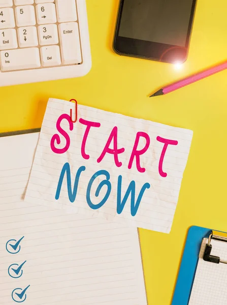 Schrijfbriefje met Start Now. Zakelijke foto presentatie aarzel dan niet om te werken of dingen te doen meteen Verfrommeld wit papier op tafel paperclips klok mobiel en pc toetsenbord. — Stockfoto