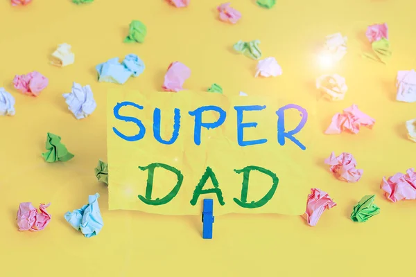 Handwriting text writing Super Dad. Concept meaning Children idol and super hero an inspiration to look upon to Colored crumpled papers empty reminder white floor background clothespin.