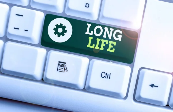 Writing note showing Long Life. Business photo showcasing able to continue working for longer than others of the same kind White pc keyboard with note paper above the white background.