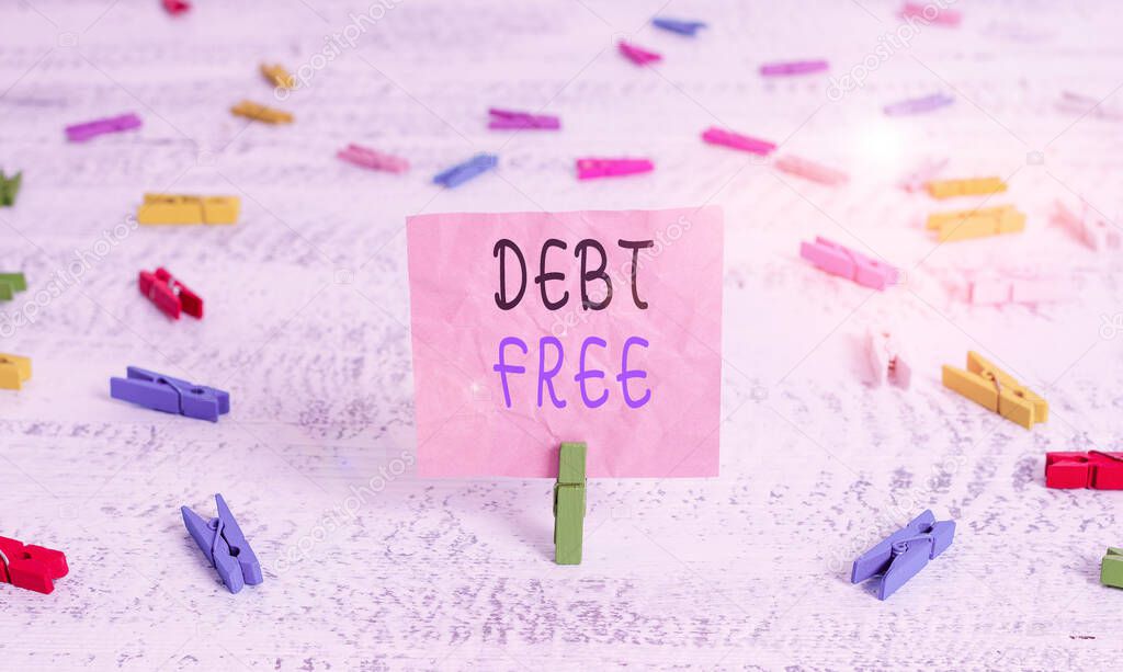 Writing note showing Debt Free. Business photo showcasing free from owning any money to any individual or a company Green clothespin white wood background reminder office supply.