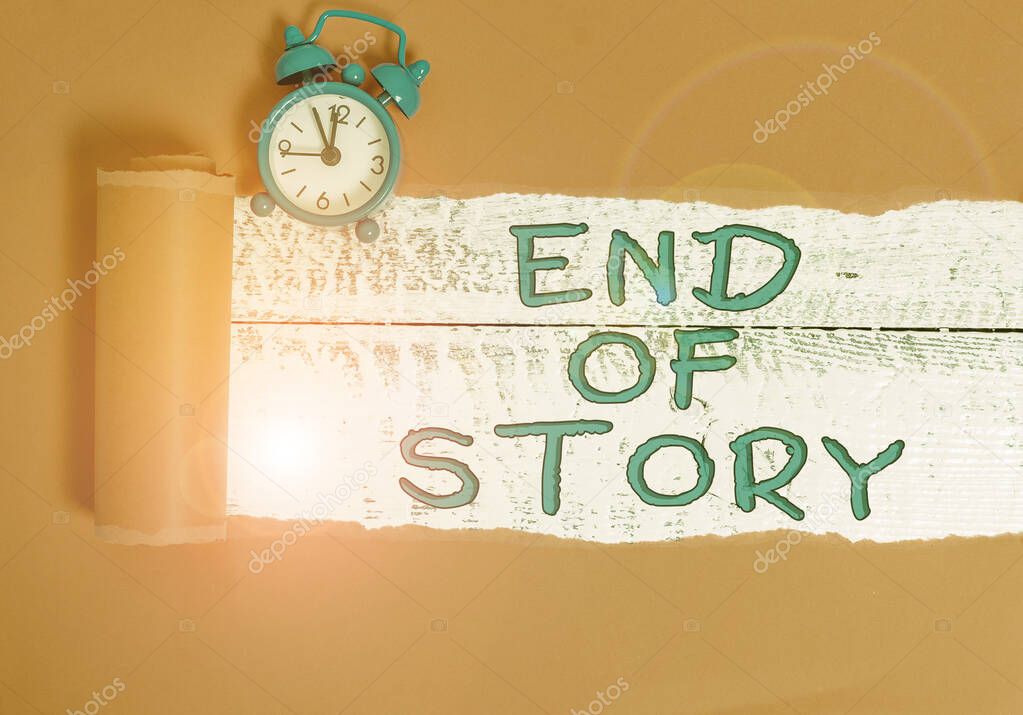 Handwriting text writing End Of Story. Concept meaning Emphasize that nothing to add Literature writing Journalism Alarm clock and torn cardboard placed above a wooden classic table backdrop.