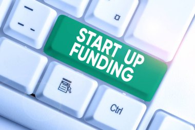 Start Up Funding 'i gösteren not yazılıyor. İş fotoğraflarının sergilenmesi, yeni kurulan şirketlere ya da beyaz arkaplanının üzerinde not kağıtları olan Beyaz PC klavyelerine yatırım yapmaya başladı.
