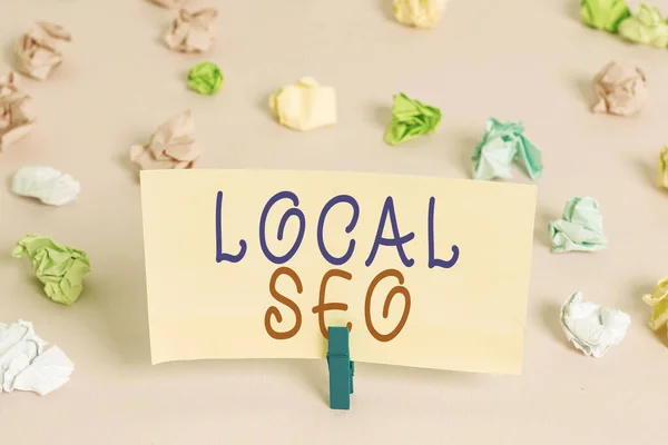 Word writing text Local Seo. Business concept for optimize your website to rank better for a local audience Colored crumpled papers empty reminder pink floor background clothespin. — 스톡 사진