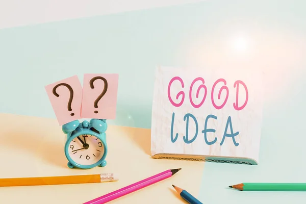 Escribiendo una nota que muestra Buena Idea. Foto de negocios mostrando una excelente sugerencia y plan para lograr algo Mini reloj despertador de tamaño junto a estacionario sobre fondo pastel . — Foto de Stock