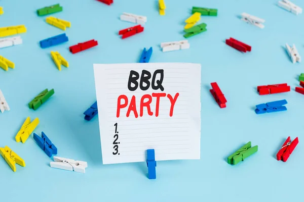 Word writing text Bbq Party. Business concept for usually done outdoors by smoking meat over wood or charcoal Colored clothespin papers empty reminder blue floor background office pin.