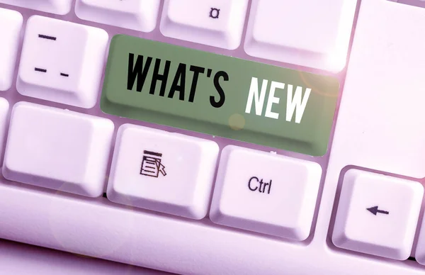 Schreibnotiz, die zeigt, was neu ist. Business-Foto präsentiert Fragen über die neuesten Aktualisierungen Trends und geschieht Nachrichten weiße PC-Tastatur mit Notizpapier über dem weißen Hintergrund. — Stockfoto