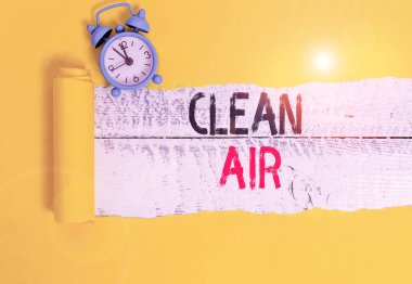 Temiz hava gösteren kavramsal el yazısı. Zararlı miktarda toprak ve kimyasal içermeyen iş fotoğrafı havası. Alarm saati ve ahşap masa arkaplanındaki karton yırtılması..