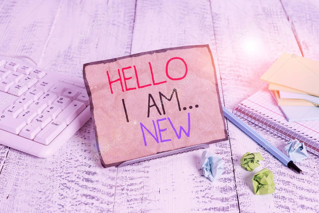 Conceptual hand writing showing Hello I Am New. Business photo showcasing Introduce yourself Meeting Greeting Work Fresh worker School Notepaper on wire in between computer keyboard and sheets.