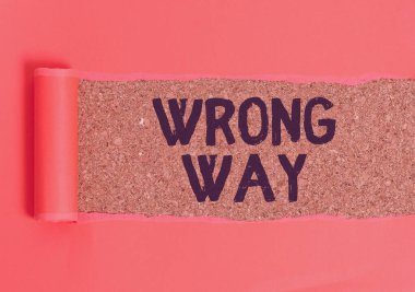 Text sign showing Wrong Way. Conceptual photo taking an unsuitable or undesirable analysisners or direction Cardboard which is torn in the middle placed above a wooden classic table.