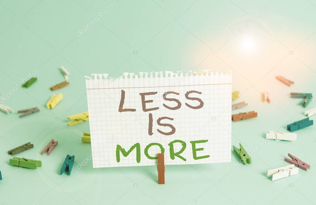 Word writing text Less Is More. Business concept for Minimalist approach to artistic matter is more effective Colored clothespin rectangle square shaped paper light blue background.