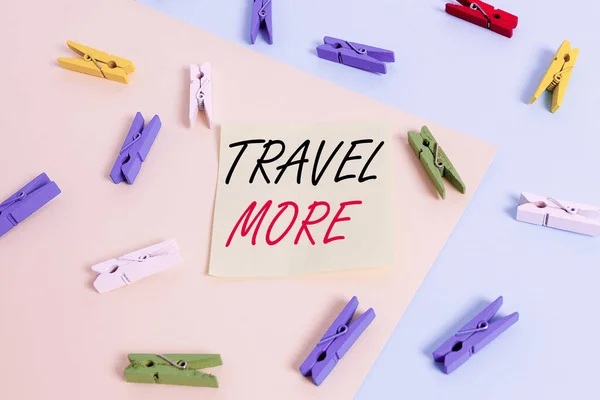 Word writing text Travel More. Business concept for To make a journey often especially on long distance trip Colored clothespin paper empty reminder yellow blue floor background office.