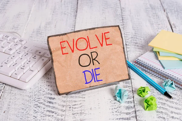 Conceptual hand writing showing Evolve Or Die. Business photo showcasing Necessity of change grow adapt to continue living Survival Notepaper on wire in between computer keyboard and sheets. — Stok fotoğraf