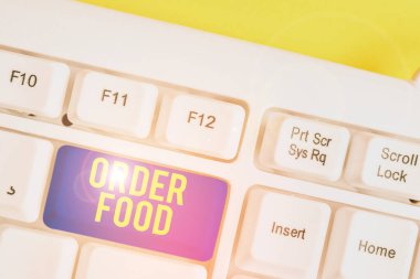 Text sign showing Order Food. Conceptual photo the process of requesting a preferred food in a restaurant White pc keyboard with empty note paper above white background key copy space.