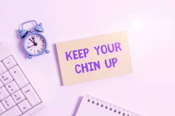 Conceptual hand writing showing Keep Your Chin Up. Business photo text Remain cheerful in difficult circumstances High Spirit Keyboard with empty note paper and pencil white background.