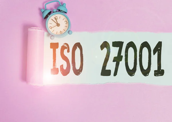 Textschild mit ISO 27001. Konzeptionelle Foto-Spezifikation für ein Informationssicherheits-Analysesystem Wecker und zerrissenen Karton über einfachen Pastelltischhintergrund platziert. — Stockfoto