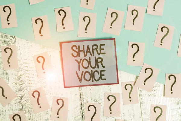 Handwriting text Share Your Voice. Concept meaning asking employee or member to give his opinion or suggestion Scribbled and crumbling papers with thick cardboard above wooden table.