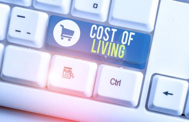 Kelime yazma, Yaşamanın Maliyeti. Günlük ögelerin aralığıyla ilgili iş konsepti Beyaz pc klavye üzerinde boş not kağıdı olan beyaz arkaplan anahtar alanı.
