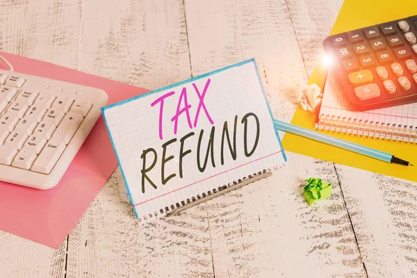 Texte indiquant Remboursement d'impôt. Remboursement conceptuel de photo sur la taxe lorsque la taxe exigible est inférieure à la taxe payée Support de papier pour ordinateur portable sur fil tampon entre le clavier de l'ordinateur et les feuilles de mathématiques . — Photo