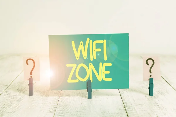 Szövegírás Wifi zóna. Üzleti koncepció vezeték nélküli nagy sebességű internet és hálózati kapcsolatok biztosítására Írásos és omladozó lap fából készült asztalra helyezett gemkapcsokkal. — Stock Fotó