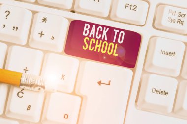 Okula Dönüş tabelasını gösteriyor. Kavramsal fotoğraf Yeni Öğretmenler Arkadaşları Üniformaları Kitaplar Üniforma Destekleme Ücreti Beyaz pc klavye kağıt üzerinde beyaz arkaplan anahtar boşluk.