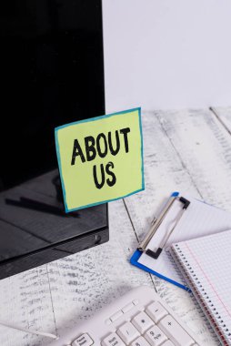 Bizim hakkımızda mesaj işareti. Klavye ve sabit bilgisayarın yanındaki siyah bilgisayar ekranına bantlanmış not kağıdıyla kimin veya neyin ilişkili ya da neyle ilgili olduğunu tanıtmak için kavramsal fotoğraf.