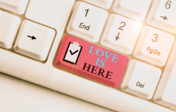 Escribiendo una nota que muestra que el amor está aquí. Foto de negocios mostrando Roanalysistic feeling Emoción encantadora Expresión positiva Cuidado Joy White teclado de PC con papel de nota sobre el fondo blanco . — Foto de Stock