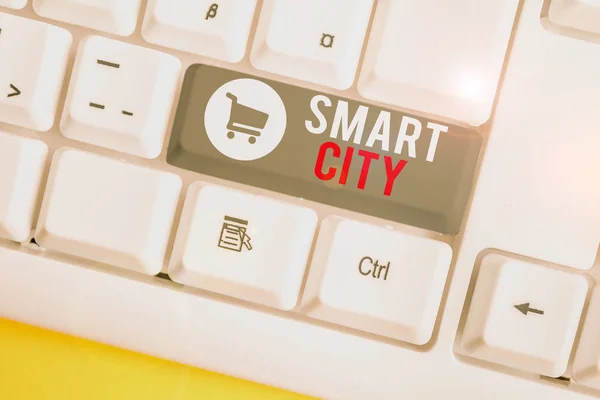 Konceptuální rukopis ukazující Smart City. Obchodní foto text městská oblast, která používá různé elektronické Internet věcí bílá PC klávesnice s poznámkovým papírem nad bílým pozadím. — Stock fotografie