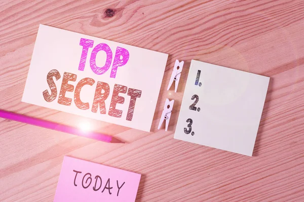 Conceptual hand writing showing Top Secret. Business photo text protected by a high degree of secrecy Highly confidential Colored crumpled papers wooden floor background clothespin. — Stockfoto