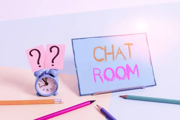 Writing note showing Chat Room. Business photo showcasing area on the Internet or computer network where users communicate Mini size alarm clock beside stationary on pastel backdrop. — Stock Photo, Image